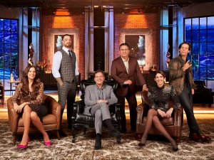 Portal Jaciara Barros – Seis pessoas, vestidas de forma formal e casual, posam para foto em estúdio moderno e iluminado, com poltronas ao fundo. – Portal Jaciara Barros