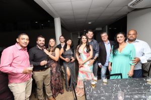 Portal Jaciara Barros – Dez adultos, entre eles um soldado, posam em evento interno com trajes semi-formais; alguns seguram bebidas. – Portal Jaciara Barros