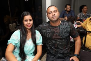 Portal Jaciara Barros – Um soldado fardado e uma mulher de vestido azul-claro estão sentados juntos em uma mesa de restaurante. – Portal Jaciara Barros