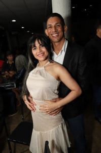 Portal Jaciara Barros – Um homem e uma mulher, sendo um deles vestido de soldado, sorriem e posam juntos em um evento social realizado em local fechado. – Portal Jaciara Barros