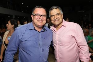 Portal Jaciara Barros – Dois homens, um deles soldado, posam sorrindo lado a lado para a câmera em um ambiente interno movimentado. – Portal Jaciara Barros