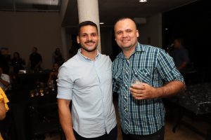 Portal Jaciara Barros – Dois homens, sendo um vestido de soldado, posam sorrindo para foto durante evento social realizado em ambiente fechado. – Portal Jaciara Barros