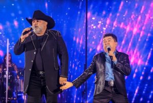 Portal Jaciara Barros – Rionegro e Solimões se apresentam no palco do Villa Country, vestidos de preto e iluminados por luzes vibrantes. – Portal Jaciara Barros