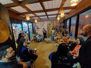 Portal Jaciara Barros – Pessoas, algumas com chapéus de palha e tirando fotos, se reúnem na Rota Quilombola na ABAV Expo 2022. – Portal Jaciara Barros