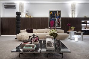 Portal Jaciara Barros – A sala de estar moderna reúne sofá bege, mesa de mármore e obra abstrata inspirada na CASACOR São Paulo. – Portal Jaciara Barros