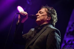 Portal Jaciara Barros – Fábio Júnior se apresenta no palco do festival, cantando ao microfone sob iluminação roxa. – Portal Jaciara Barros