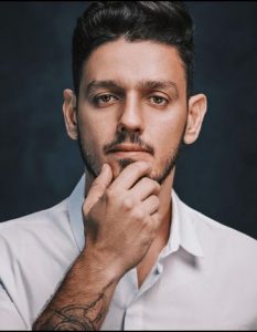 Portal Jaciara Barros – Homem de cabelo escuro e barba, veste camisa branca, posa para a câmera com expressão neutra. Foto: Glauber Matos. – Portal Jaciara Barros