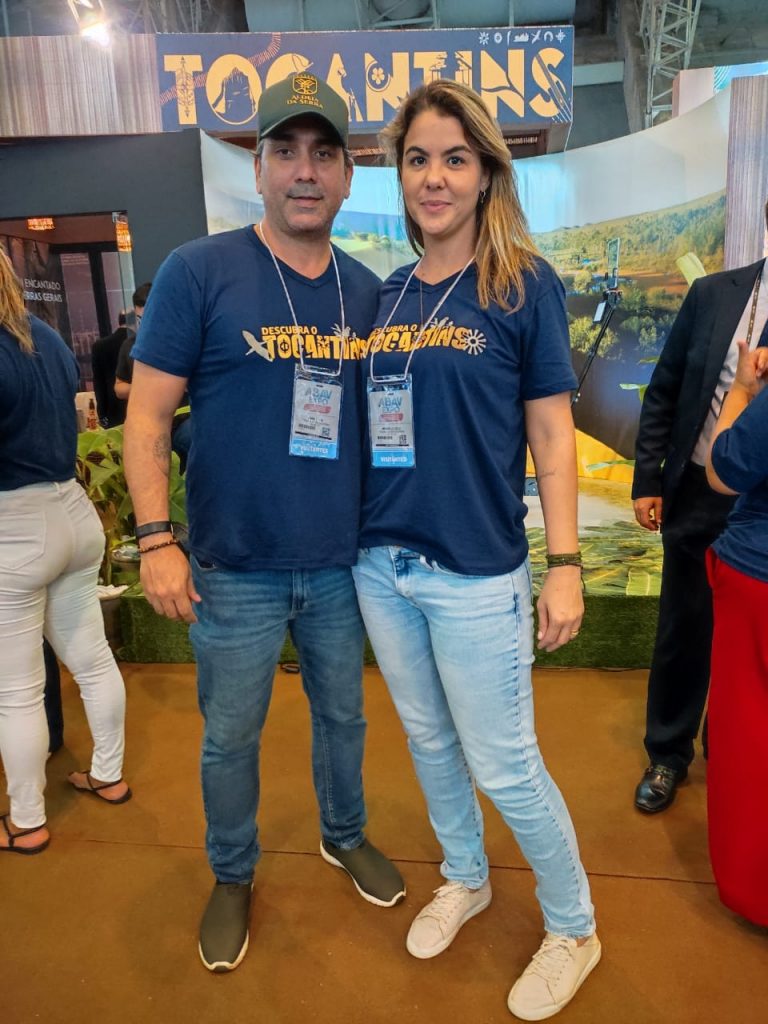 Portal Jaciara Barros – Fábio e Michelle Lélis, vestidos com camisas azuis, divulgaram ações em estande identificado com a placa Tocantins. – Portal Jaciara Barros