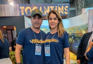 Portal Jaciara Barros – Fábio e Michelle Lélis, vestidos com camisas azuis, divulgaram ações em estande identificado com a placa Tocantins. – Portal Jaciara Barros