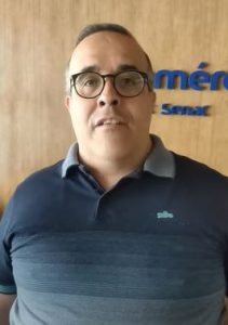 Portal Jaciara Barros – Homem de cabelo curto e óculos, veste camisa azul-marinho e está ao lado de parede de madeira com a inscrição ABAV-TO em azul. – Portal Jaciara Barros