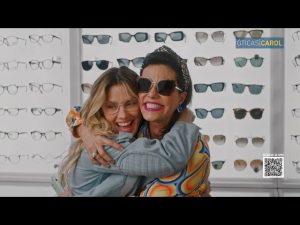 Portal Jaciara Barros – Duas mulheres de óculos se abraçam e sorriem diante de uma vitrine na conhecida ótica Óticas Carol. – Portal Jaciara Barros