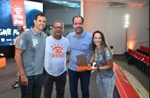 Portal Jaciara Barros – Quatro pessoas posam em ambiente interno durante evento do Rally dos Sertões, uma delas segura uma placa; logos "30 Sertões" ao fundo. – Portal Jaciara Barros