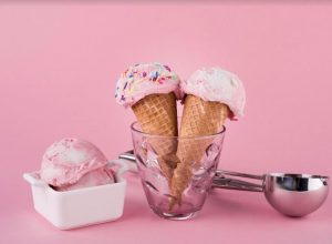 Portal Jaciara Barros – Dois cones de sorvete em um copo, uma tigela de sorvete rosa e uma colher ilustram o crescimento do setor. – Portal Jaciara Barros