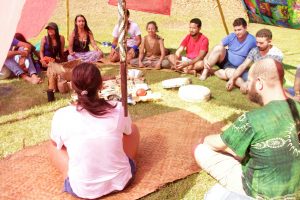 Portal Jaciara Barros – Pessoas sentadas em círculo em tapetes ao ar livre participam da programação do Movimento Pela Vida 2022 sob a luz do sol. – Portal Jaciara Barros