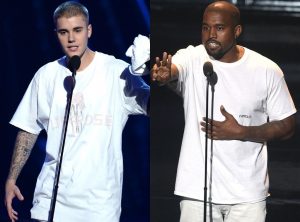 Portal Jaciara Barros – Kanye West e Justin Bieber, ambos de camiseta branca, falam ao microfone em um palco escuro, cada um em seu próprio púlpito. – Portal Jaciara Barros
