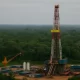 Plataforma de petróleo cercada pela floresta amazônica, simbolizando o conflito entre exploração econômica e preservação ambiental.