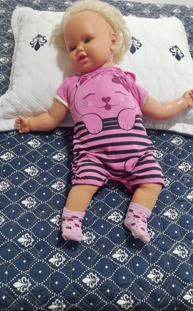 primeira boneca da irmã Nayara, que tem quase 40 anos. Hoje, minha mãe cuida dela como se fosse um bebê, compra roupa, coloca deitada na cama e se chama Bilubilu