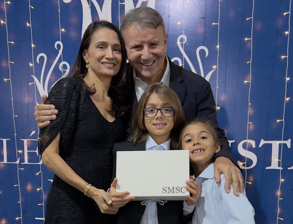 Samuel, filho do prefeito Eduardo Siqueira Campos e de Polyanna, celebra o rito da caneta no Colégio Marista em um momento cheio de ternura e significado.