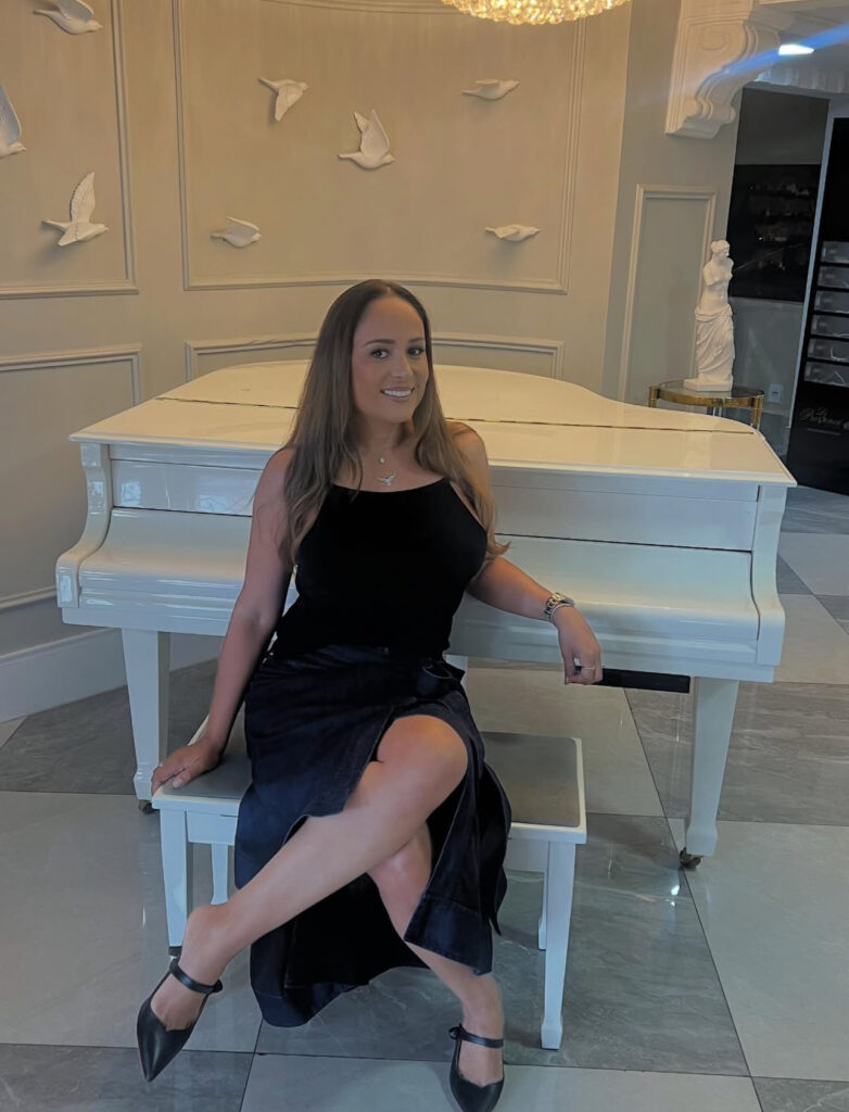 Marcia Mascanhes sentada em um piano